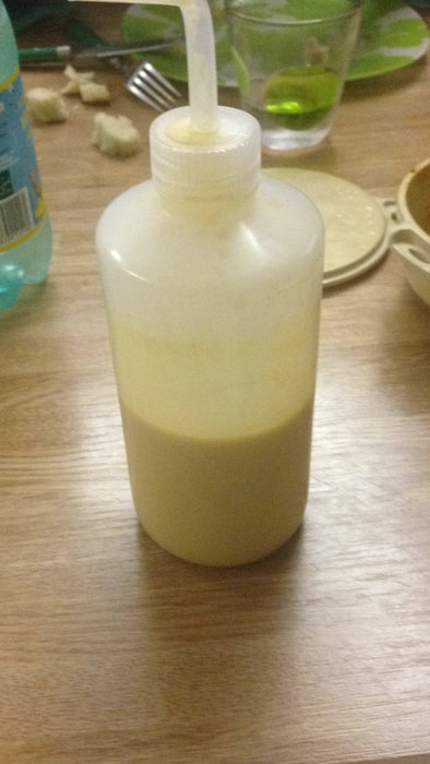 Bouteille à pipette contenant une recette de repas liquide nutritif, idéale pour une alimentation post-opératoire après une chirurgie maxillo-faciale, posée sur une table de cuisine.